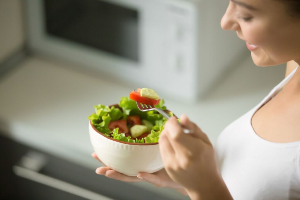 Foto de mulher com tigela de vegetais para uma refeição saudável. Nutrição e saúde. Check Up Hospital.
